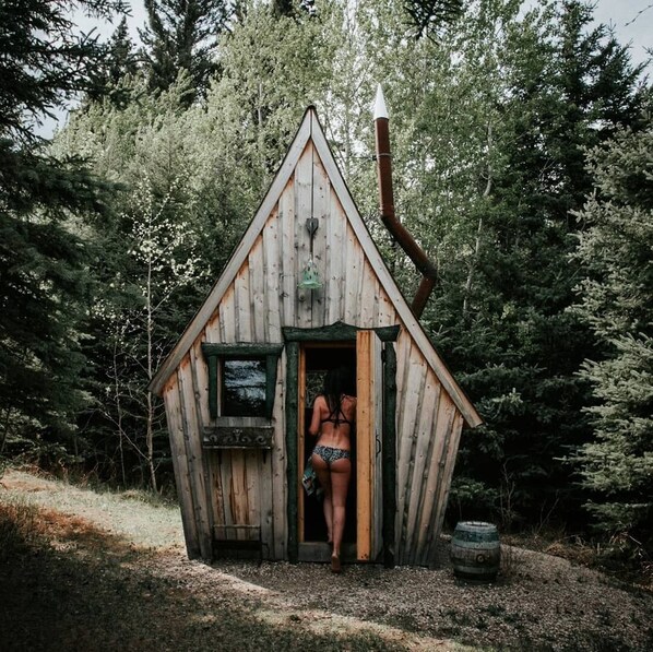 A small wooden cabin with a triangular roof, a single window, and a door.