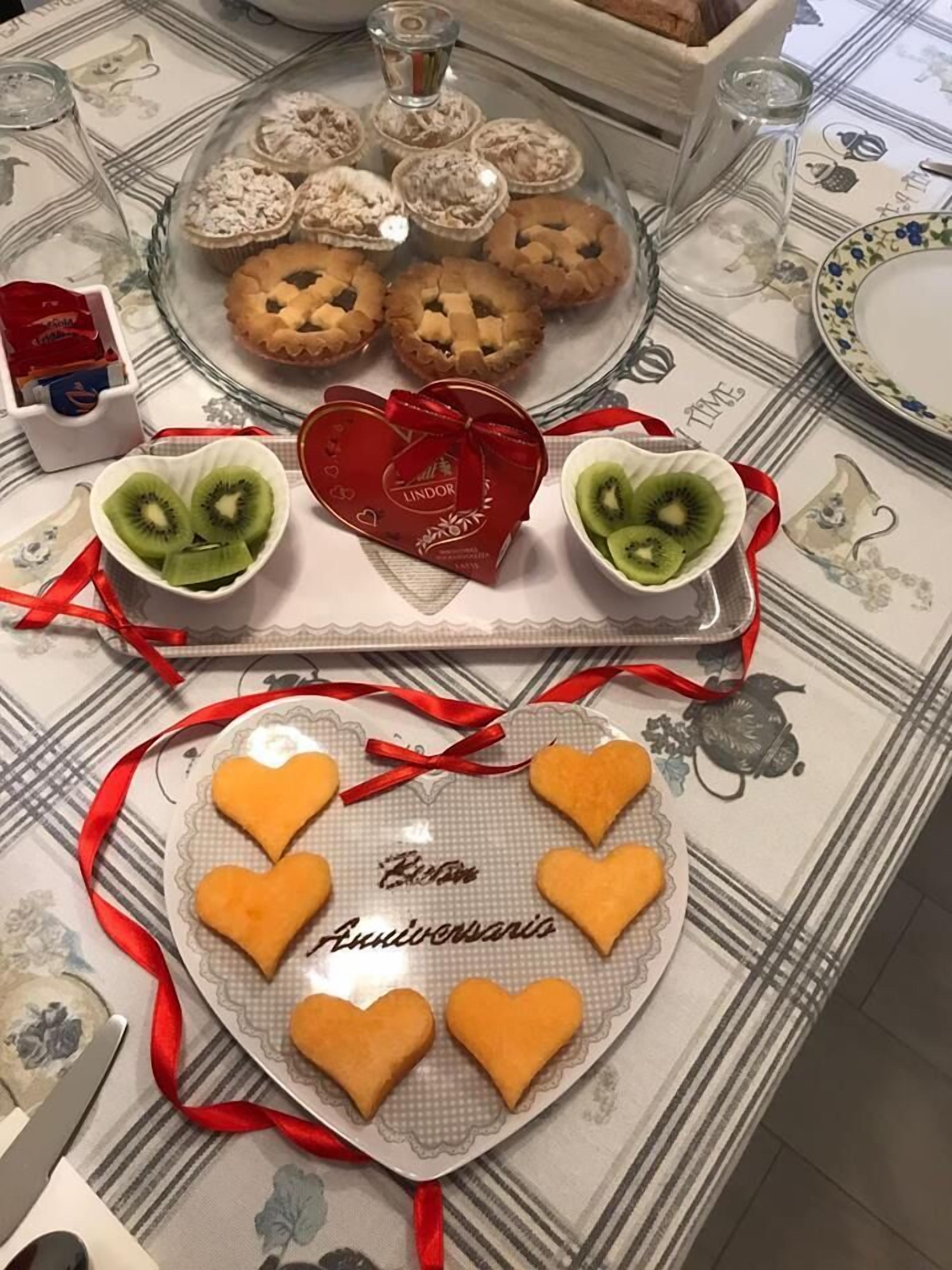 A table with heart-shaped cookies, a glass cake display, and a Lindor heart-shaped box.