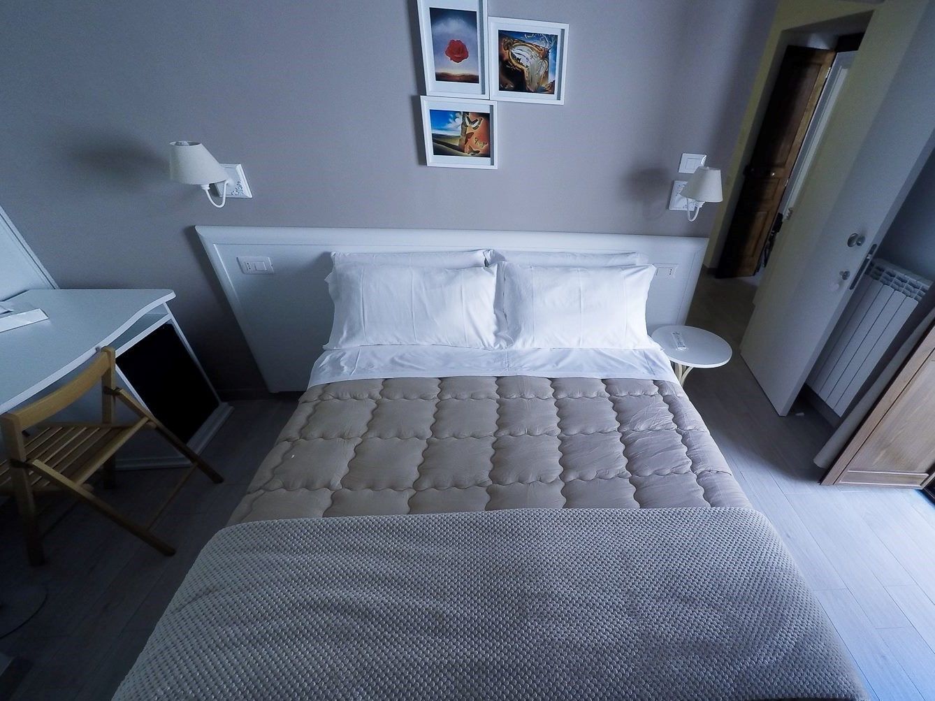 A neatly arranged bedroom with a bed, a desk, and a chair.