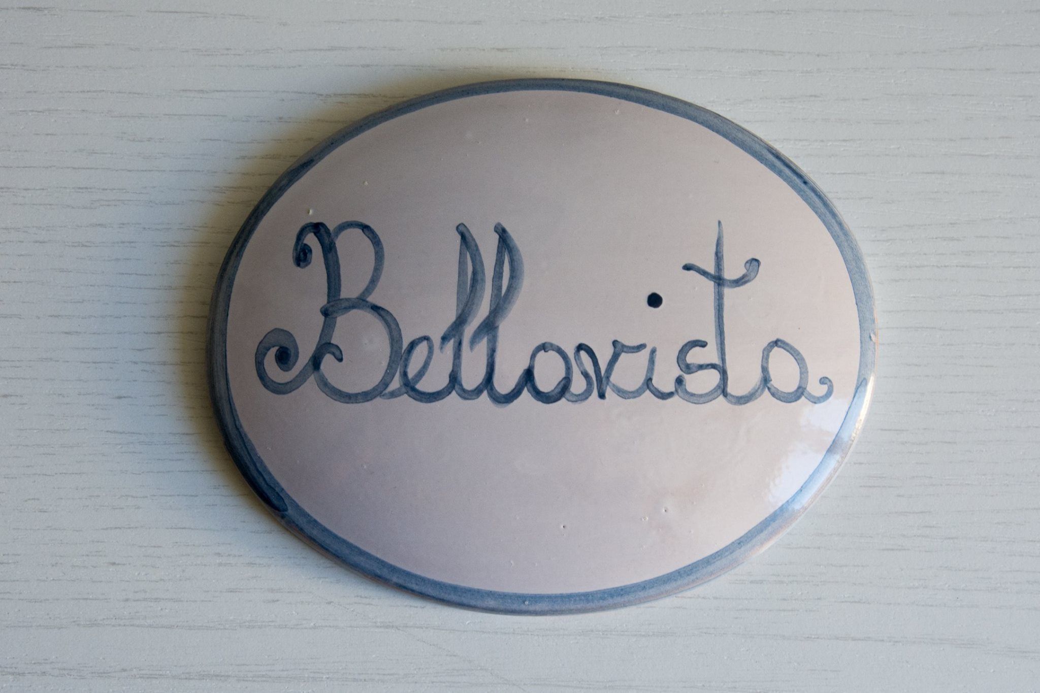 Ein rundes, beige Keramikschild mit der aufgeschriebenen Bezeichnung 'Bellavista'.