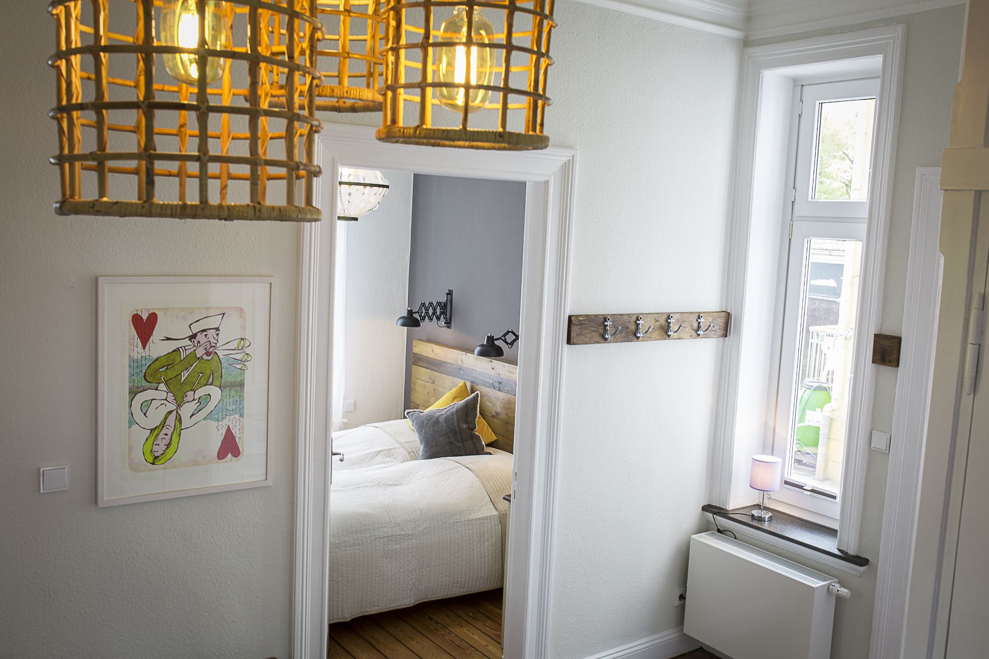 Een slaapkamer met een bed, nachtkastje, lamp en uitzicht.