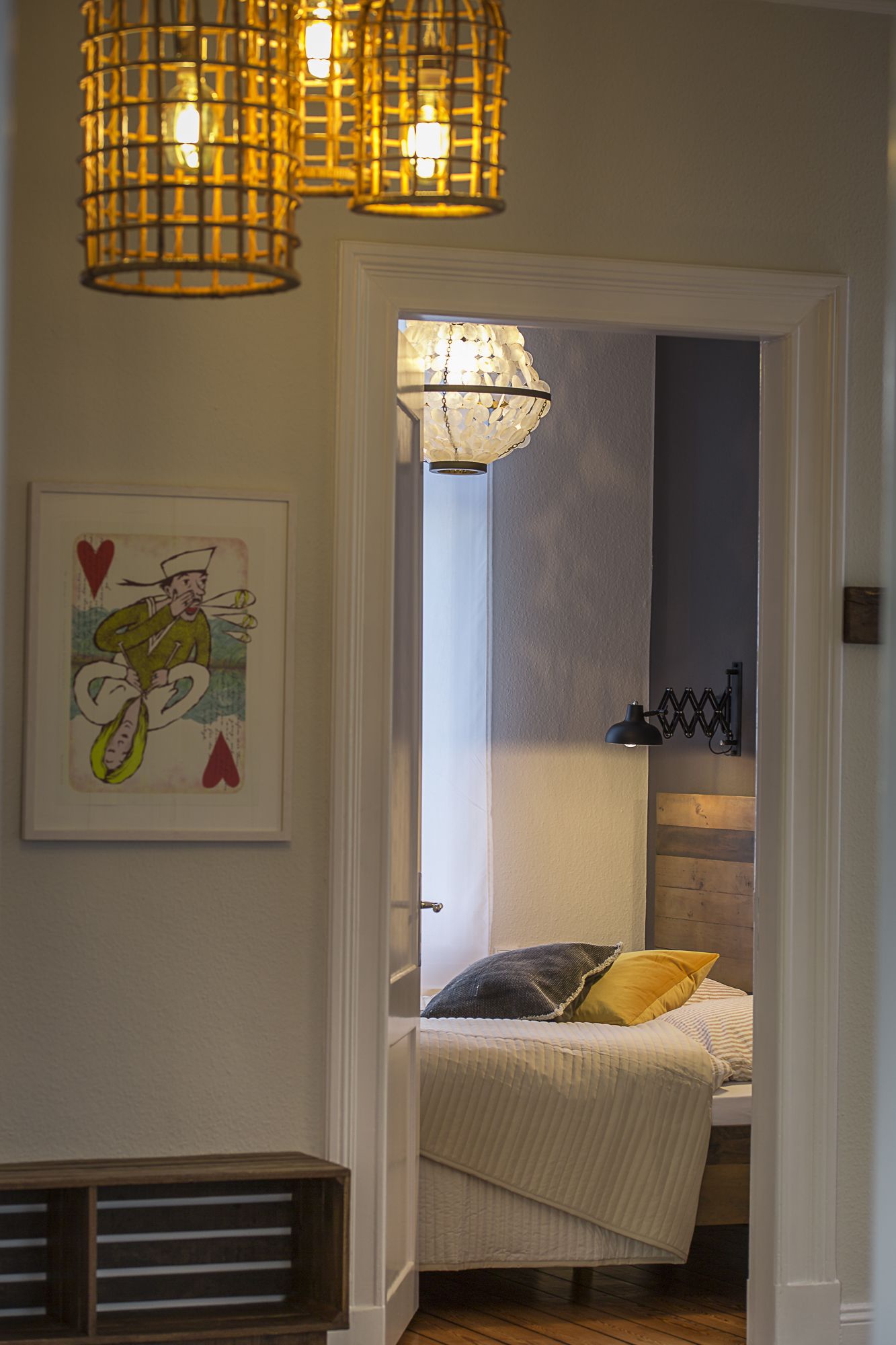 Ein Schlafzimmer mit einem Bett, einem Nachttisch, einer Lampe und einem gerahmten Bild an der Wand.