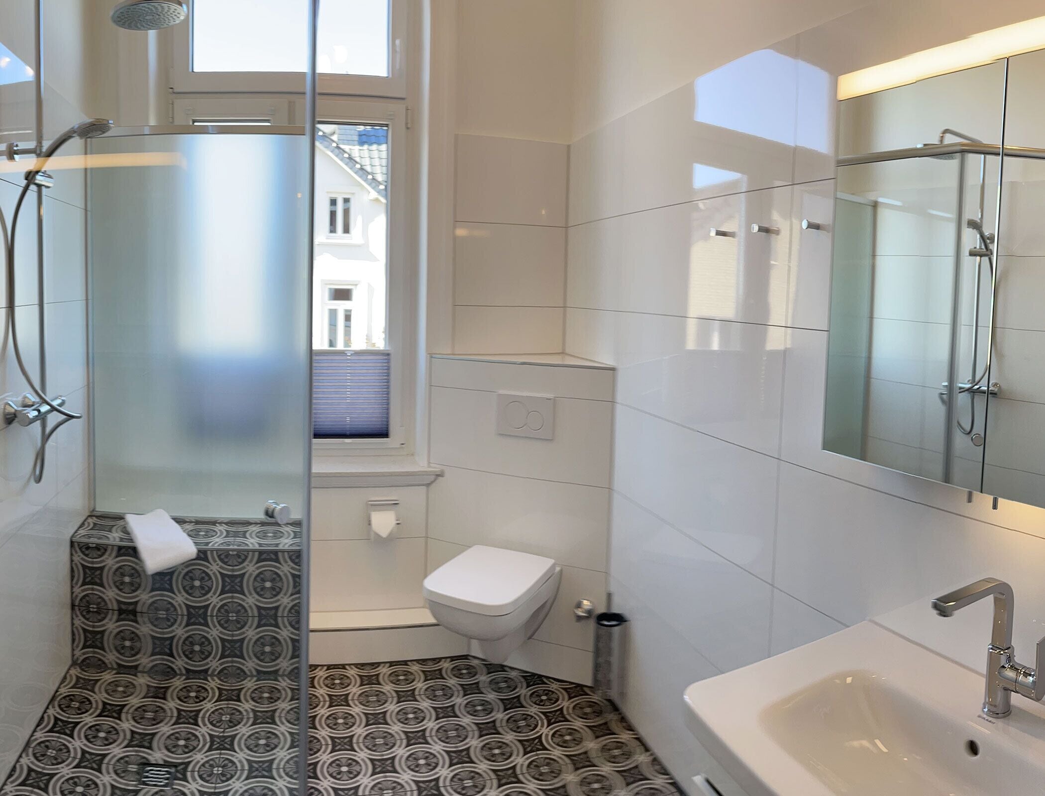 Un baño moderno con ducha, inodoro y lavabo.