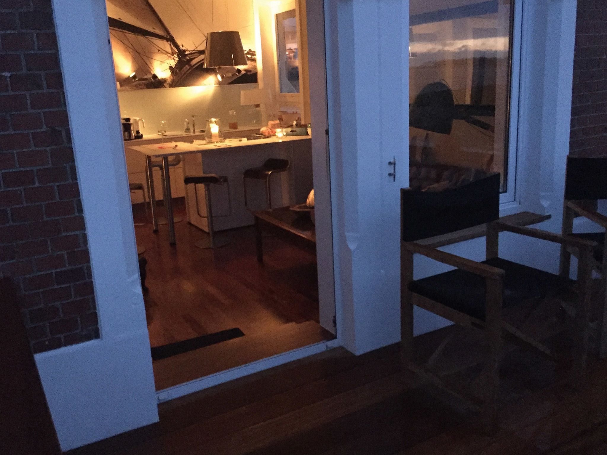 Een keuken met een barstoel, een eettafel en een koelkast.