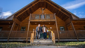 A wooden lodge with a prominent front porch and a balcony. - Red Bank Lodge - Red Bank, New Brunswick (Sillikers)