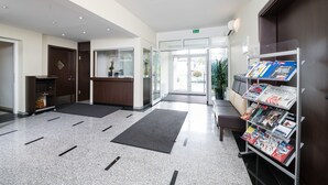 Een receptie met een balie, een wachtruimte met een bank en een tijdschriftenrek.