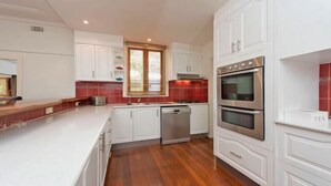 Una cocina moderna con armarios blancos, horno de acero inoxidable y lavavajillas.