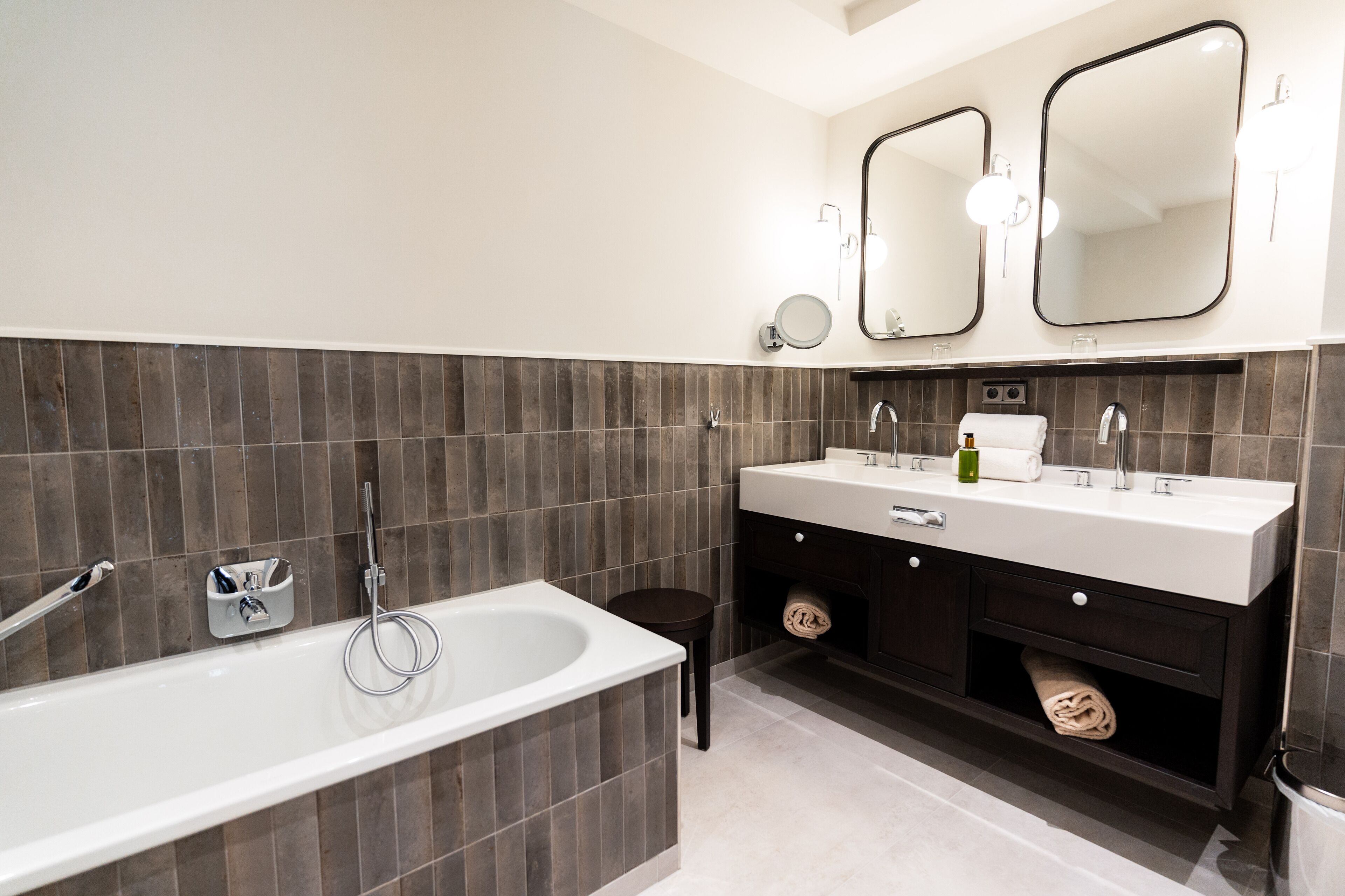 Ein modernes Badezimmer mit einer Badewanne, zwei Waschbecken und einem Waschtisch mit Schubladen.