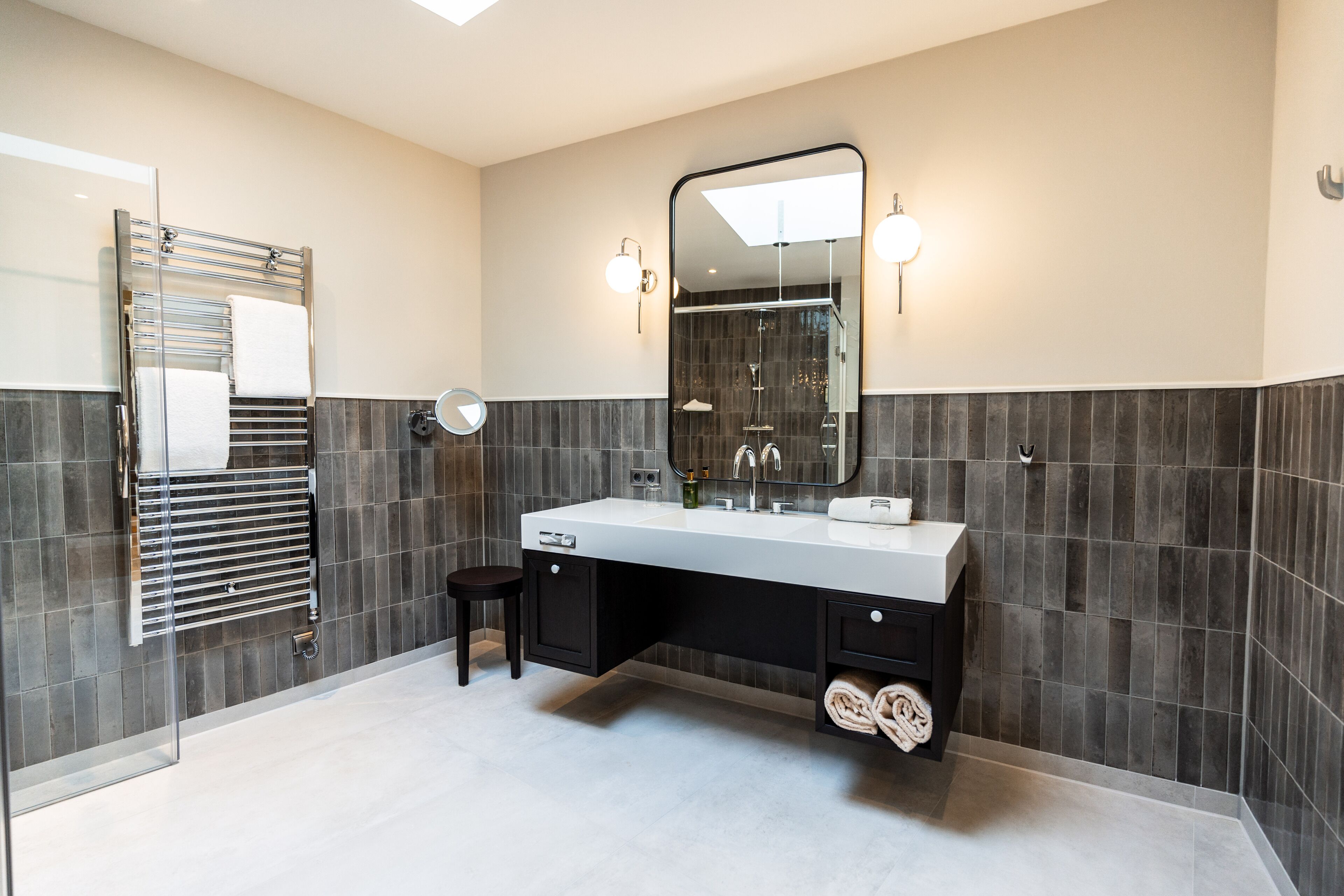 A modern bathroom with a glass shower enclosure, a double sink vanity, and a large mirror.