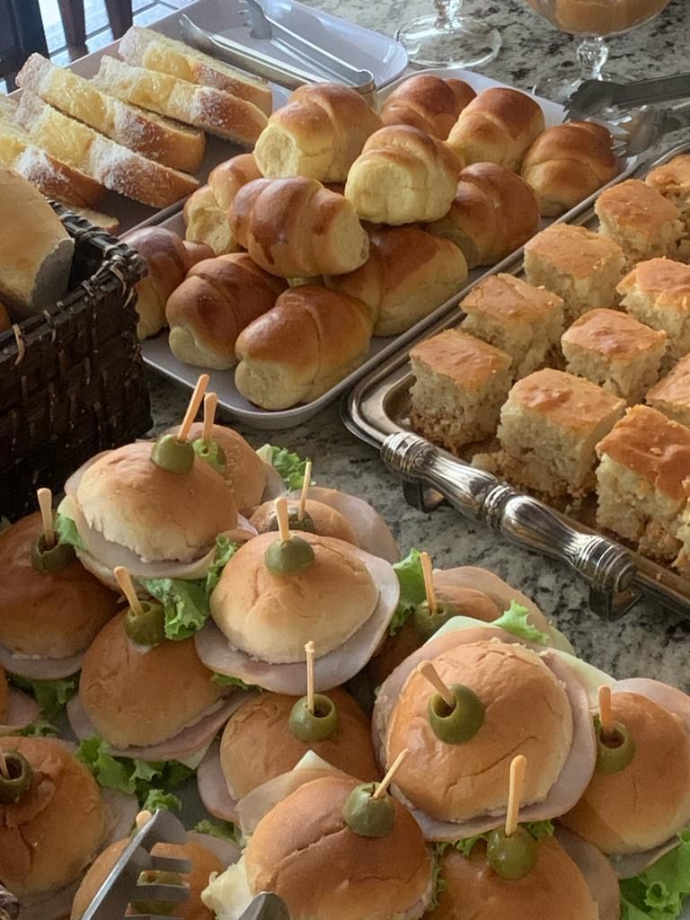 Une variété de produits de boulangerie, notamment des petits pains, des croissants et des sandwichs aux olives, présentés sur un plateau.