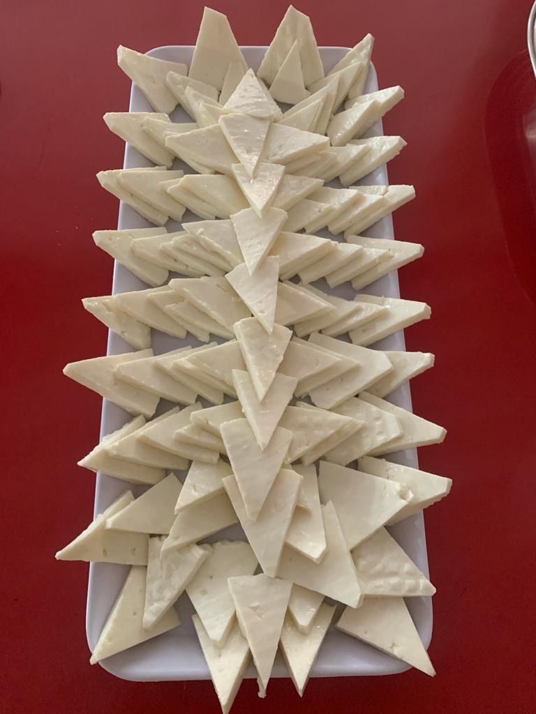 Un plato rectangular blanco con piezas triangulares blancas dispuestas en un diseño.