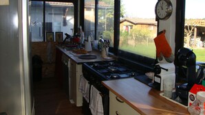 Eine Küche mit einem großen Fenster, einem Herd und verschiedenen Küchengeräten.