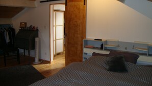 Ein Schlafzimmer mit einem Bett, einem Schminktisch, einem Schreibtisch und einem Kleiderschrank.