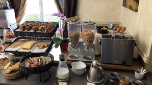 Un bufé con diversos alimentos, incluyendo pan, pasteles y frutas.
