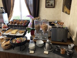 A buffet with various food items including bread, pastries, and fruits.