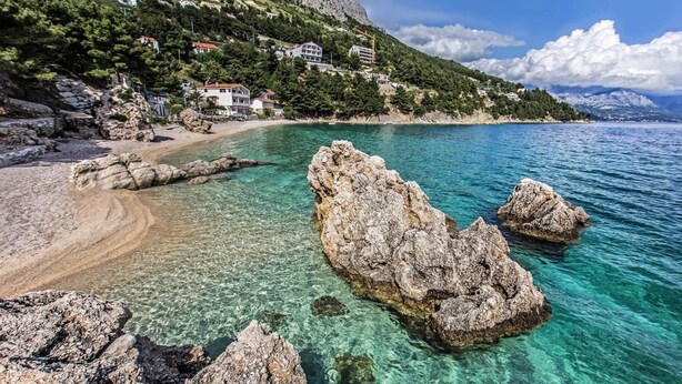 A coastal area with clear waters, rocky formations, and buildings on a hillside. - 2 Bedroom, 4 Guests, Direct on a stunning beach (Mimice)