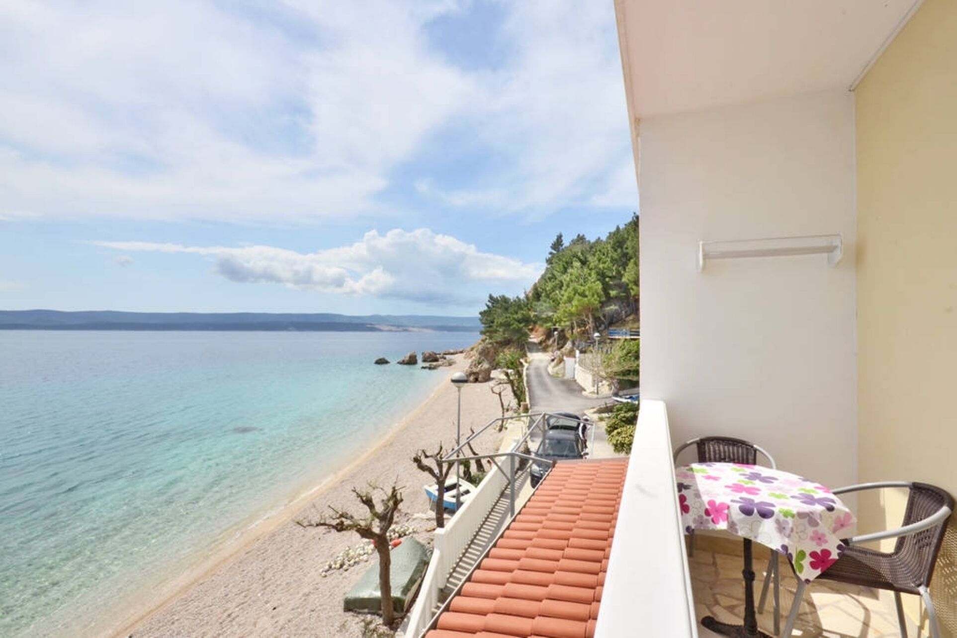 Un balcon avec vue sur une plage et la mer.