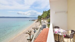 A balcony with a view of a beach and the sea. - 2 Bedroom, 4 Guests, Direct on a stunning beach (Mimice)