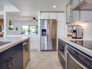 A modern kitchen with stainless steel appliances, a dishwasher, and a coffee maker.