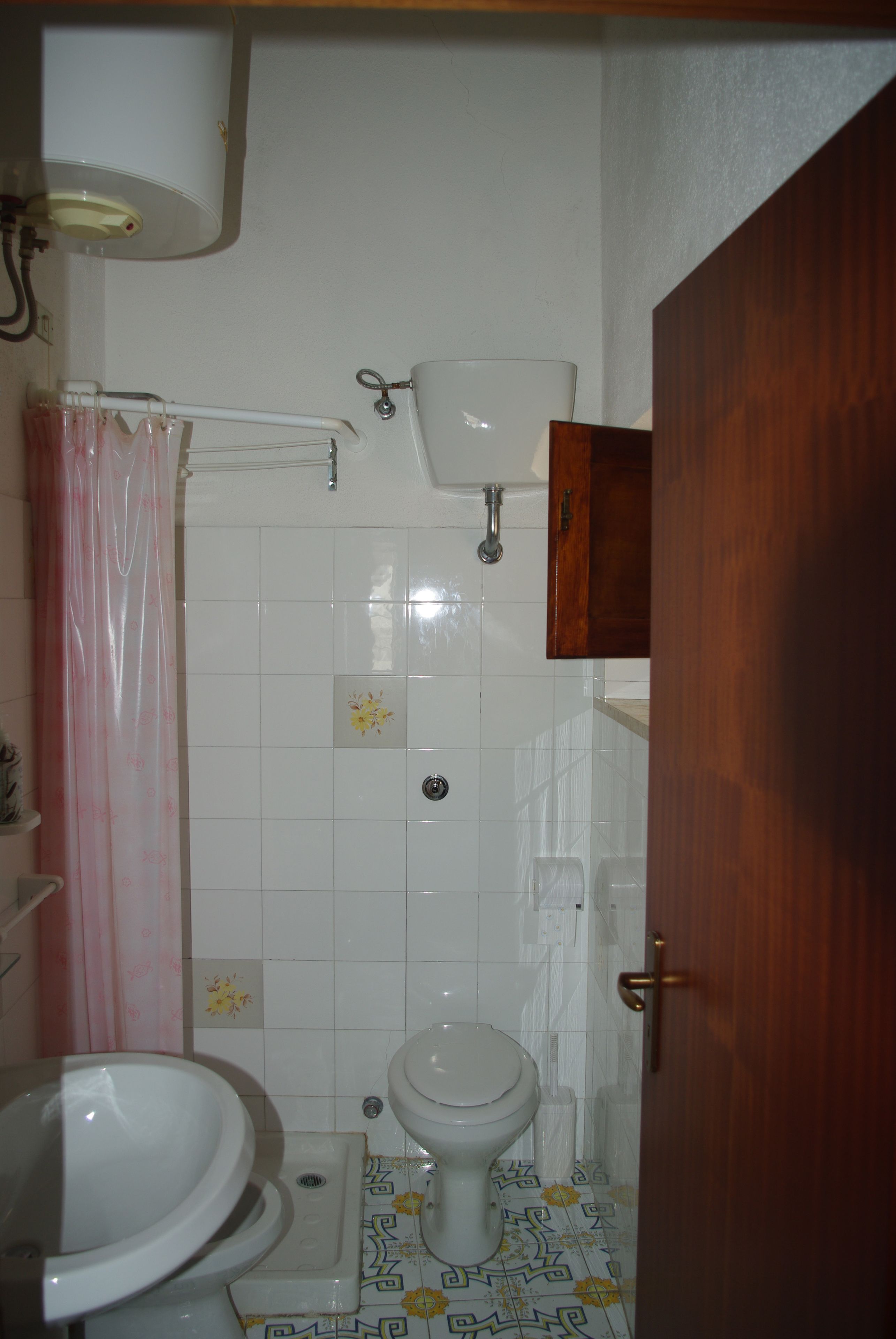 Un baño pequeño con inodoro, lavabo y ducha.