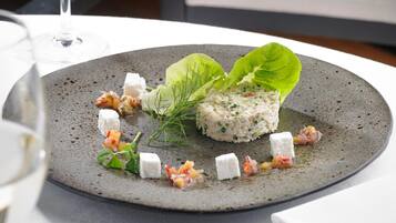 A plate of food with a salad, cheese, and a drink on the table.