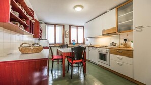 Una cucina compatta con mobili bianchi, un tavolo da pranzo e sedie.