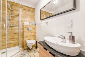 A modern bathroom with a shower, toilet, and vanity.