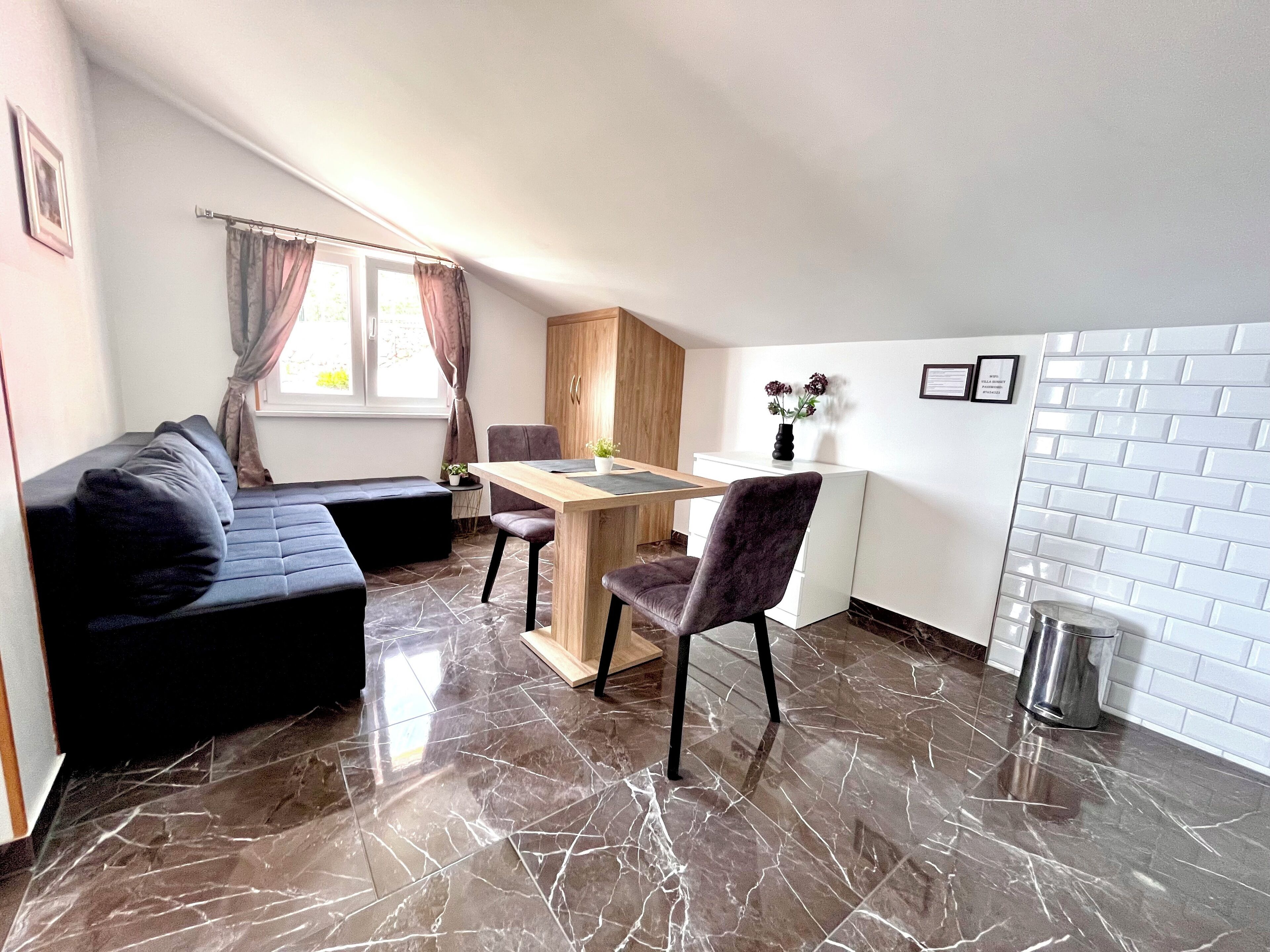 A compact living space with a sofa, a dining table, and a kitchen area.