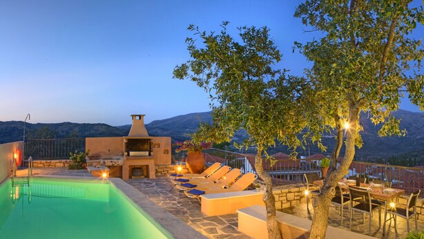 A poolside area with lounge chairs, a barbecue, and a view of the mountains. - Amari Villas: calm and comfort in the real Crete (Rethymno)