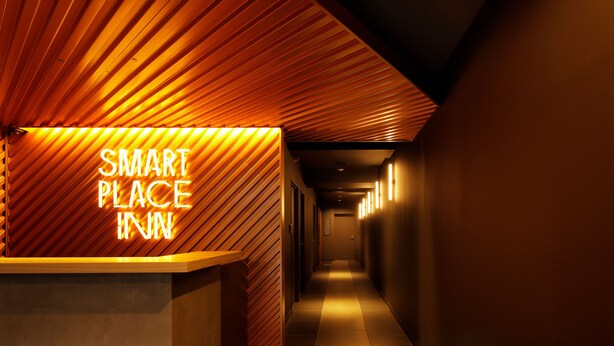 A hallway with a reception desk and a sign that reads "SMART PLACE INN". - Smart Place Inn Kyoto Shijo Omiya East (Kyoto)