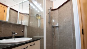 Une salle de bain moderne avec un lavabo, un miroir et une douche.