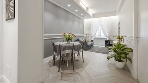 Un salon moderne avec un coin repas, des murs gris, un canapé gris et une plante en pot.