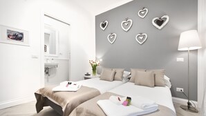 Une chambre d’hôtel moderne avec deux lits, une salle de bain et des décorations murales en forme de cœur.