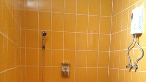 Um banheiro com uma banheira branca, chuveiro e luminária na parede.
