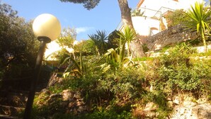A garden with a stone wall, various plants, and a lamp post. - monaco holiday house blue coast montecarlo (Beausoleil)