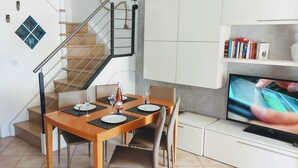 A modern kitchen with a dining area, a staircase, and a TV. - monaco holiday house blue coast montecarlo (Beausoleil)