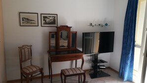 A room with a wooden desk, two chairs, a mirror, a flat-screen TV, and two framed pictures on the wall. - monaco holiday house blue coast montecarlo (Beausoleil)