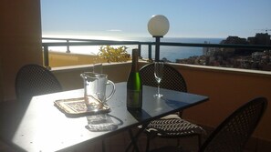 A balcony with a table, chairs, a bottle, a wine glass, and a pitcher. - monaco holiday house blue coast montecarlo (Beausoleil)