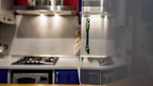 A kitchen with a stove, oven, and a hanging green object. - Cozy Suite Arena Milano Santa Giulia (MILANO)