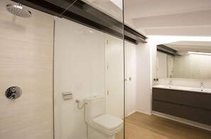 A modern bathroom with a glass shower enclosure, a toilet, and a vanity with a mirror. - BEAUTIFUL MALLORQUINA HOUSE (POLLENSA)