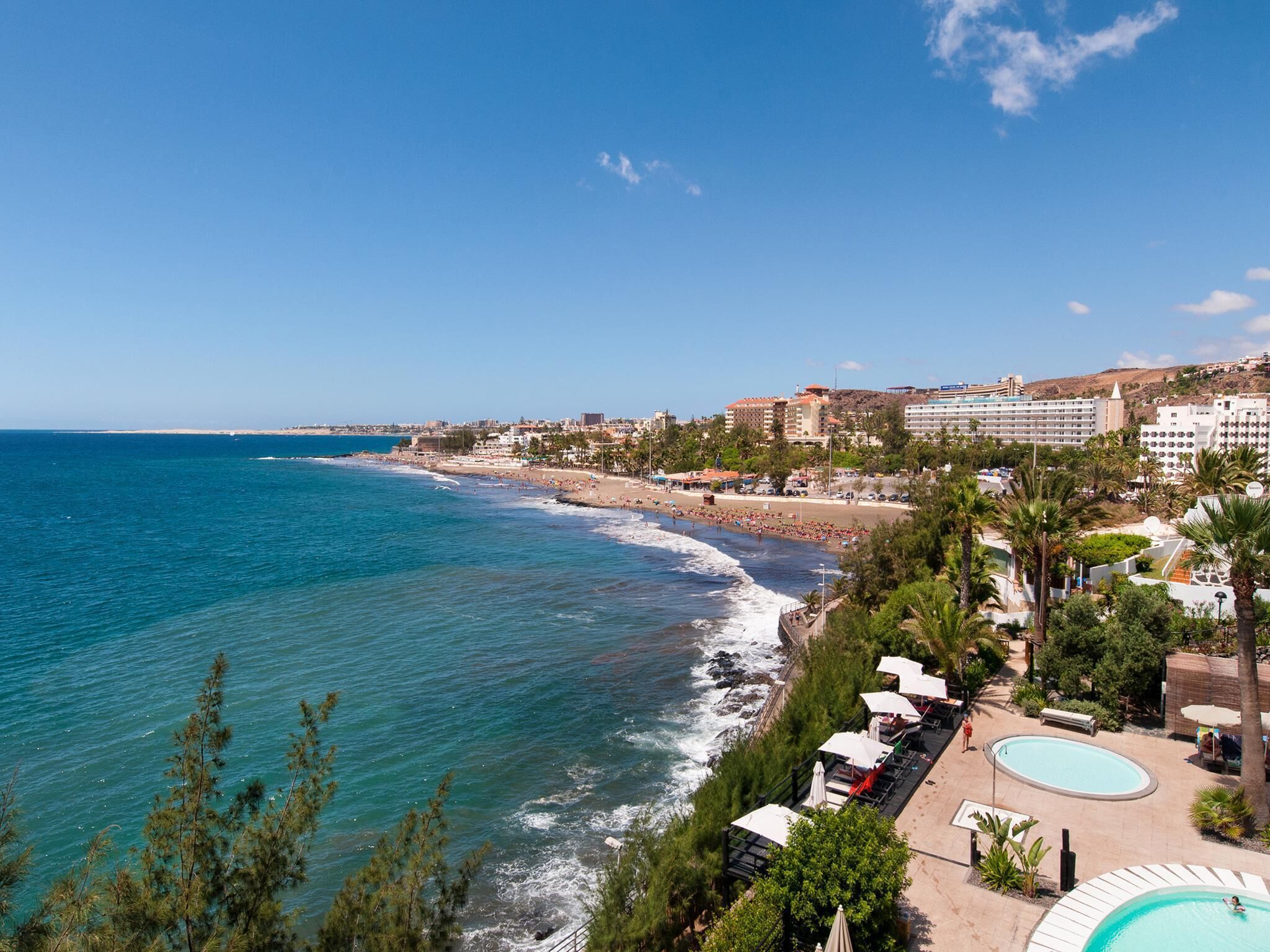 Une station balnéaire dotée d’une plage, d’une piscine et offrant une vue sur l’océan.