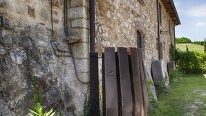 Ein rustikales Steinhaus mit Holztür und Metallglocke.