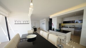 A modern kitchen with white cabinets, a black countertop, and stainless steel appliances. - Contemporary Villa, amazing sea views, heated infinity pool, daily maid service (Kiziltas, Kalkan)