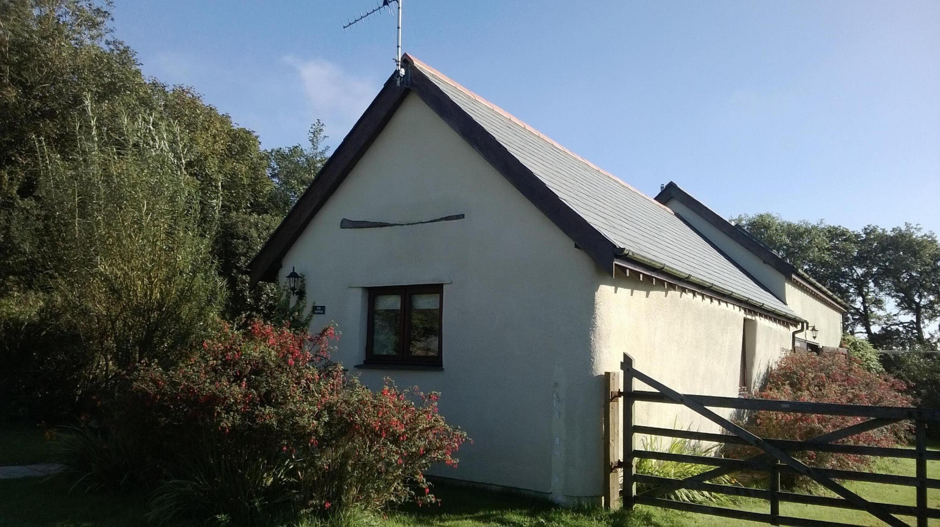 A single-story building with a pitched roof, a small window, and a visible door.