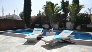 A pool area with two lounge chairs and a small table with drinks. - 'KATIKIES 22' Luxury Detached Pissouri Beach Properties, Great Relaxing Location (Pissouri)