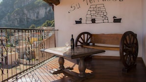 A balcony with a table, a bench, and a wall with the text "Su Terrassu". - Su Terrassu by All4sardinia  (Ulassai)