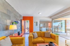 A modern living room with a sofa, a coffee table, and a lamp.