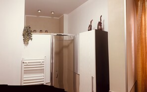 A room with a white radiator, a door, and a black cabinet with decorative items on top. - Vacation home in the immediate vicinity of Otranto (Otranto)