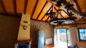 A rustic interior with a stone fireplace, wooden ceiling beams, and a stone wall. - Refuge with swimming pool, playground and incredible views - Pure Tranquillity (celorico de basto)