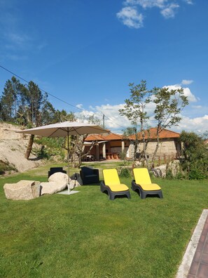 A house with a patio area, outdoor seating, and a stone facade.